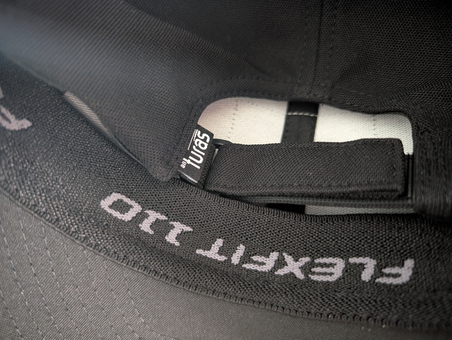 The Sòlas Cap. Close up of moisture wicking sweatband, adjustable D-Loop and the An Turas™ flag label.